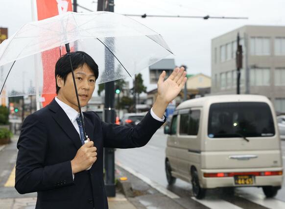つじ立ちして有権者に感謝の気持ちを伝えた梅谷守さん＝１０月２８日午前７時３０分過ぎ、上越市