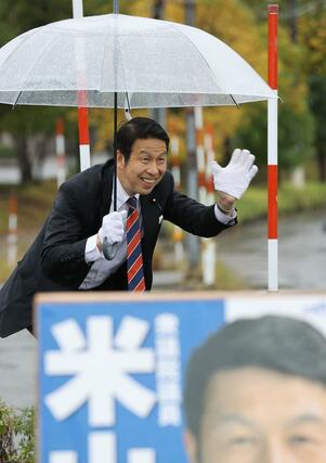 当選から一夜明け、交差点で車に手を振る米山隆一さん＝長岡市