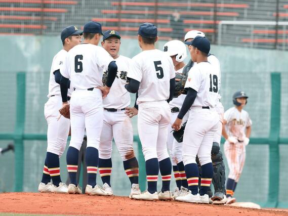 ７回、マウンドに集まる日本文理の選手たち＝富山市民球場