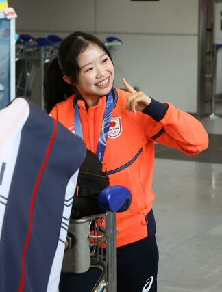 ファンの声援に応えるフィギュアスケート女子の中井亜美＝２４日、成田空港
