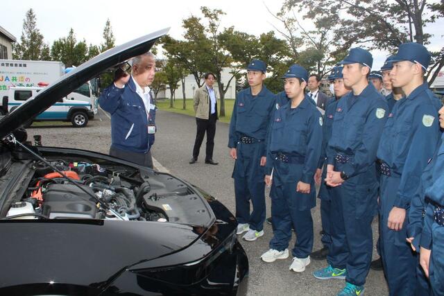 災害警備訓練で、ハイブリッド車が水没した場合の対応などについて学ぶ県警察学校の学生ら=10月22日