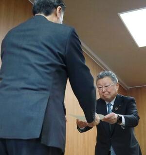 　長野県の阿部守一知事（手前）から命令書を受け取る長野県石油商業組合の高見沢秀茂理事長＝１０日午前、県庁