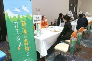 農業法人などのブースを回り、業務内容や福利厚生などの説明を聞く参加者=2月23日、新潟市中央区
