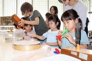 楽器を使って音が伝わる仕組みを学ぶ子どもたち=24日、長岡市千秋3