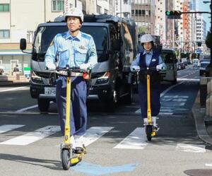 電動キックボードに乗る警察官=9日、大阪市中央区
