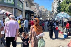 ガザ中部デールバラハの市場を歩くパレスチナ人=9月(共同)