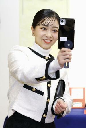 　「第５７回なるほど展」で「防災笛」として使用できるスマートフォンのスタンドを手に取られる佳子さま＝２日午前、東京・有楽町の東京交通会館