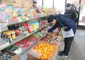 商店街の食料品店で手伝いを体験する児童=三条市林町1