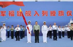 中国軍の新型空母「福建」が就役し、式典に臨む習近平国家主席(手前中央)=5日、中国海南省三亜市(新華社=共同)