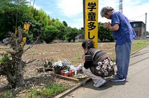事故現場付近で夫(右)と手を合わせる鈴木芳江さん=28日午前、千葉県八街市
