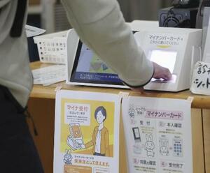 福岡市内の診療所でマイナカードを使って手続きする人=2024年12月