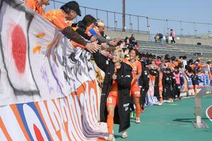 試合後、サポーターとハイタッチで勝利を喜ぶ新潟Lの選手ら=3月、新潟市陸上競技場