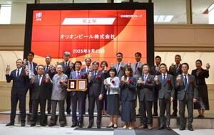 東証プライムに上場し、記念撮影をするオリオンビールの関係者ら=25日午前、東京都中央区