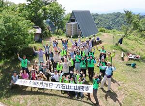 八石山の頂上で記念写真に収まる山開きの参加者=柏崎市