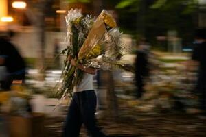 高層住宅群の大規模火災現場近くの公園から撤去される花束=7日、香港(共同)