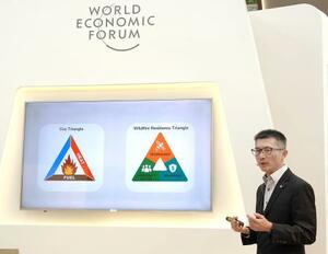 AIを活用した山火事検知の取り組みを説明する、新興企業ロボティクスキャッツの張偉健CEO=24日、中国天津市(共同)