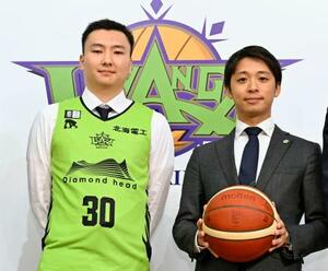 6月、バスケットボールのB1北海道に加入した富永啓生(左)と写真に納まる新オーナーの小川嶺氏=札幌市