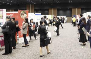 マイナビ主催の企業合同説明会で参加企業のブースを見て回る学生ら