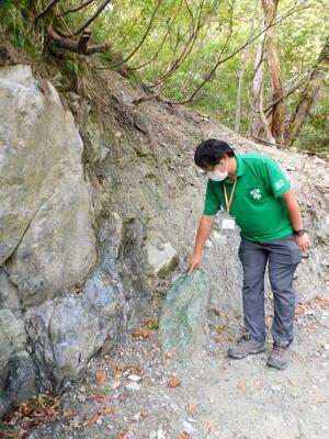 指を差しているのが今回、盗掘被害にあった「コスモクロア輝石」露頭＝２０２０年１０月撮影、糸魚川市