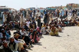 アフガニスタン・パキスタンの国境で、閉鎖措置を受けてアフガンへの帰国を待つ人々=18日、パキスタン南西部バルチスタン州(ロイター=共同)
