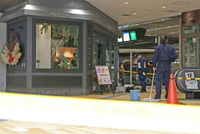 店舗付近を調べる県警の捜査員ら＝１６日、新潟市中央区万代１