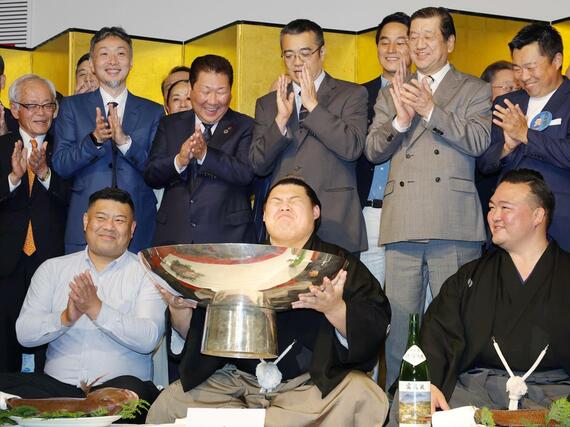 大相撲夏場所で優勝し、祝杯を手にする大の里。左は父・中村知幸さん、右は二所ノ関親方＝茨城県つくば市内のホテル