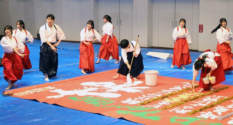 大きな筆を使ったパフォーマンスを披露する東京学館新潟高校の書道部員＝４日、新潟市中央区