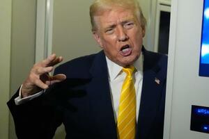 大統領専用機「エアフォースワン」の機内で報道陣の取材に応じるトランプ大統領=14日(AP=共同)