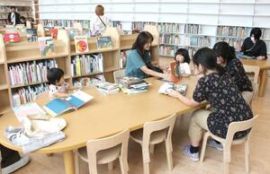 オープンした「まちなか+(ぷらす)」で本を眺める子どもたち=4日、妙高市朝日町1