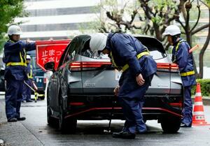 米大使館周辺で、通行車両の検問を実施する警察官=26日午前、東京・赤坂
