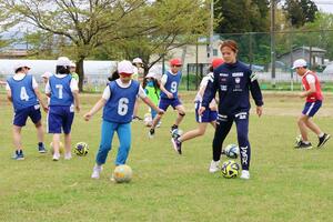 アルビレックス新潟レディースの選手と基本練習を楽しむ日吉小の児童＝長岡市鳥越