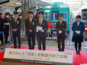 南海電鉄極楽橋駅で開かれた、観光列車「天空」(奥)の定期運行終了式典=20日午後、和歌山県高野町