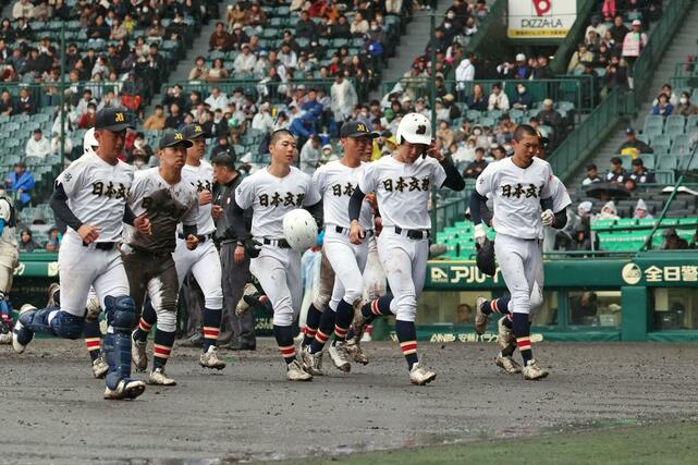 花咲徳栄に大敗し、雨の中でグラウンドを引き上げる日本文理の選手たち＝２５日、甲子園球場