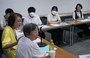 　広島原爆の日、小頭症被爆者の川下ヒロエ（手前）を囲む医療ソーシャルワーカーの村上須賀子（手前左）、河宮百合恵（右端）ら＝２０２５年８月、広島市（撮影・林昌三）