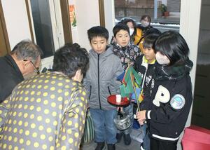 道祖神の御利益を届けようと、家々を回る子どもたち=佐渡市河原田本町