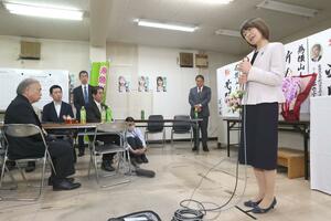 敗戦の弁を述べる横山人美さん(右)。米田徹市長(左)の後継として、自民党の中村康司県議(右から2人目)をはじめ、同党の支援を受けた=20日、糸魚川市大町1