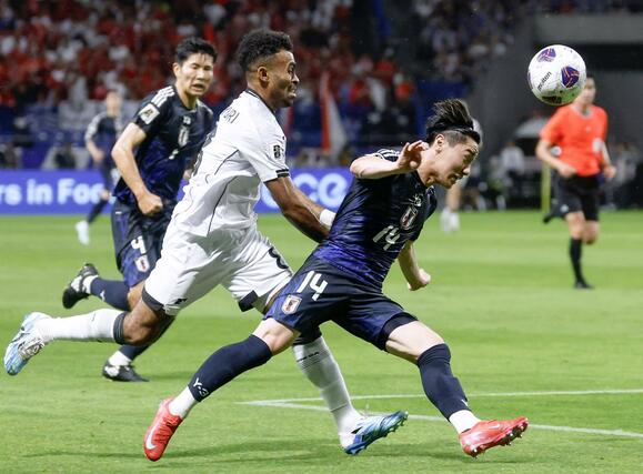 日本－インドネシア　前半、競り合う三戸（右）＝パナソニックスタジアム吹田