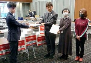 　高額療養費制度の負担上限額引き上げの撤回を求める署名を提出する全国保険医団体連合会のメンバー（右側）ら＝１９日午後、国会