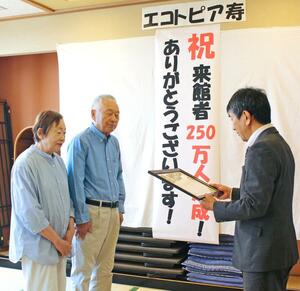 250万人目の来館者となり、認定証を受け取る伊丹髙一郎さんと百代さん夫妻=12日、長岡市寿3