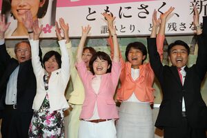 当選が確実になり、選挙戦を支えた国会議員らと万歳をする打越さく良氏(中央)=21日午後10時30分前、新潟市中央区