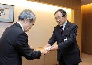 寄付金の目録を手渡す「メディアシップコミュニケーション会」の阿部正喜会長(右)=2月3日、新潟市中央区