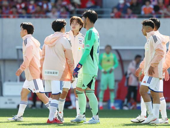 悔しがるＦＷ笠井佳祐（左から３番目）に声をかける新潟の選手たち＝金沢ゴーゴーカレースタジアム