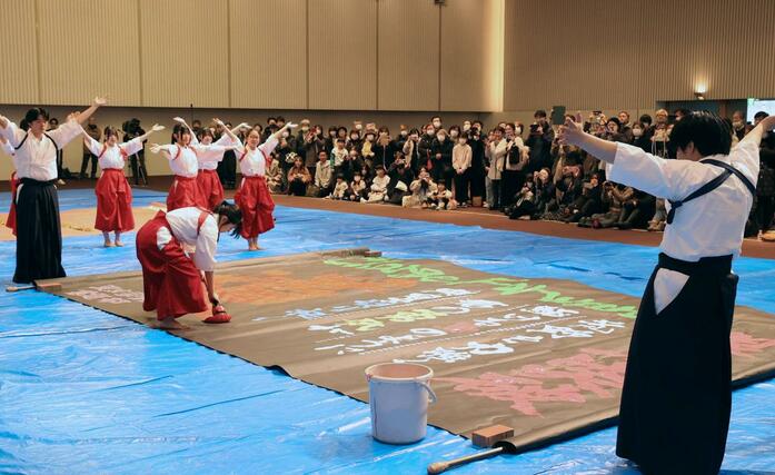 大きな筆を使ったパフォーマンスを披露する東京学館新潟高校の書道部員＝４日、新潟市中央区