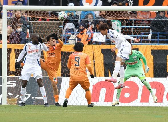 後半、相手の猛攻をしのぐ新潟の守備陣＝松山市