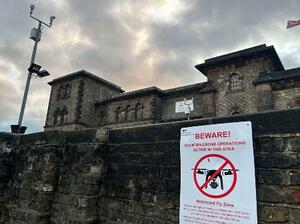 　ワンズワース刑務所の正面出入り口付近に取り付けられたドローン飛行禁止を警告する看板＝１１月、ロンドン（共同）