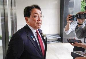 記者団の取材に応じる赤沢経済再生相=25日午前、東京・永田町の自民党本部