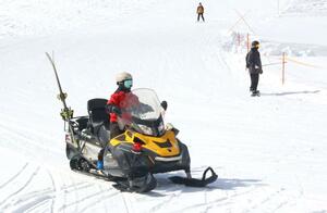 スノーモービルでゲレンデを移動するパトロール隊員=南魚沼市舞子