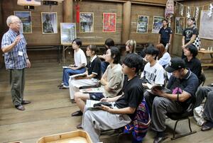 関山神社で「妙高(関山)の文化財を語る会」の川上昭治会長の説明を聞く新大生=妙高市