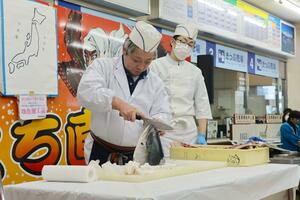 多くの来場者でにぎわったブリの解体ショー＝１８日、上越市港町１