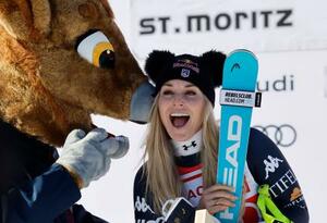 アルペンスキーW杯女子滑降、史上最年少41歳で通算83勝目を挙げ、表彰台でマスコットと喜ぶリンゼイ・ボン=12日、サンモリッツ(ロイター=共同)